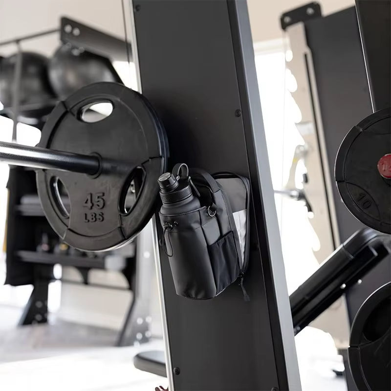 Black weight plate attached to a gym barbell with a tool pouch on a weight rack.